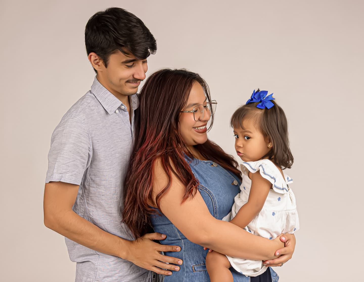 Sesión familiar en estudio con padres e hija pequeña